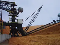 Stacker reclaimer in the middle of a circular chip pile